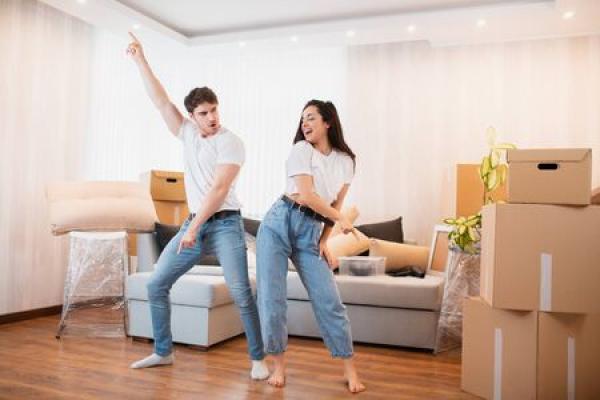 A husband and wife celebrate as they move into a new apartment