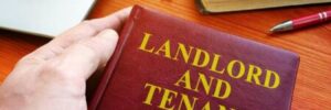 A hand holds a book that says "Landlord and Tenant Act"